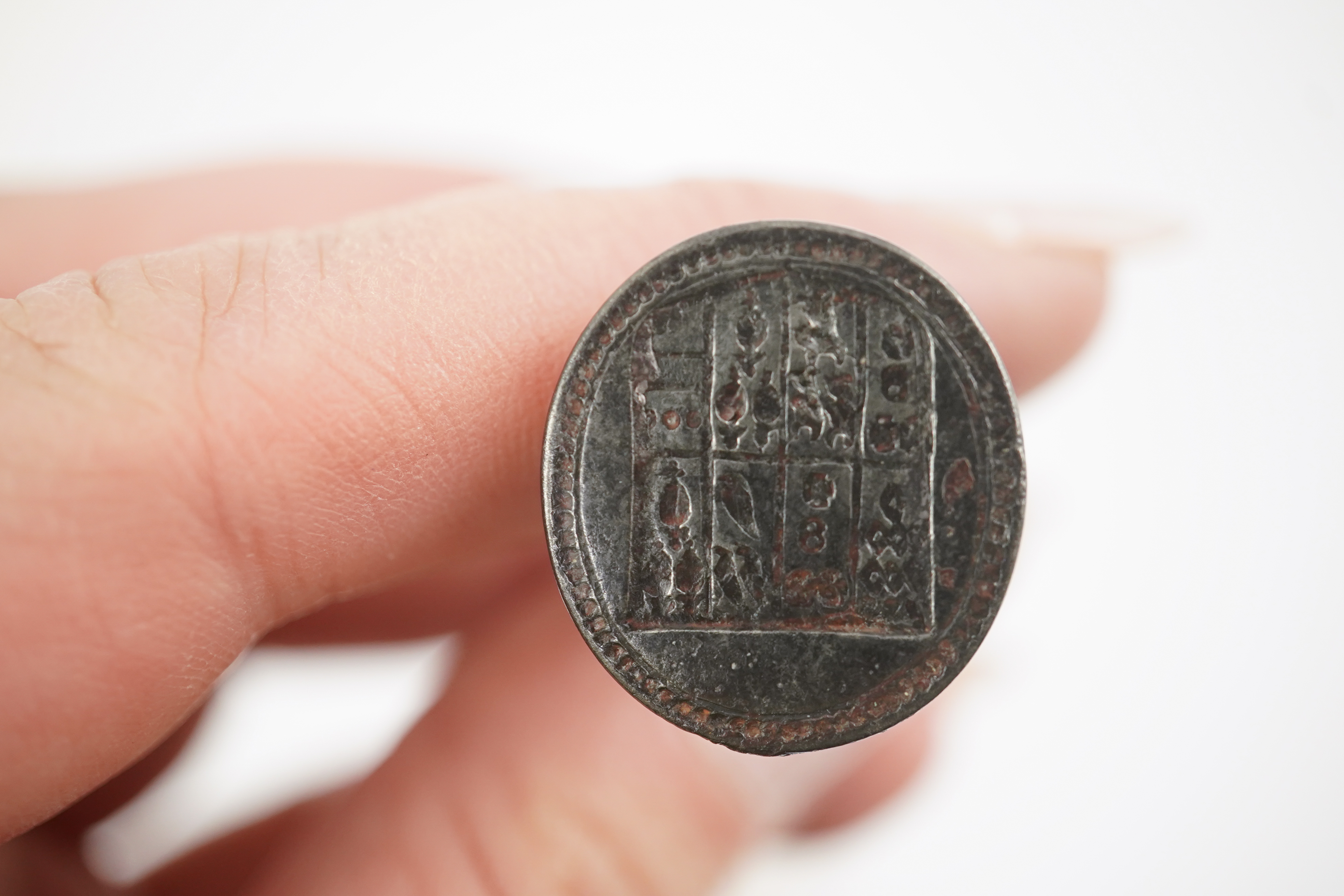 An early 18th century silver and gold signet ring, embossed with an armorial, size R, together with a steel double ended fob seal